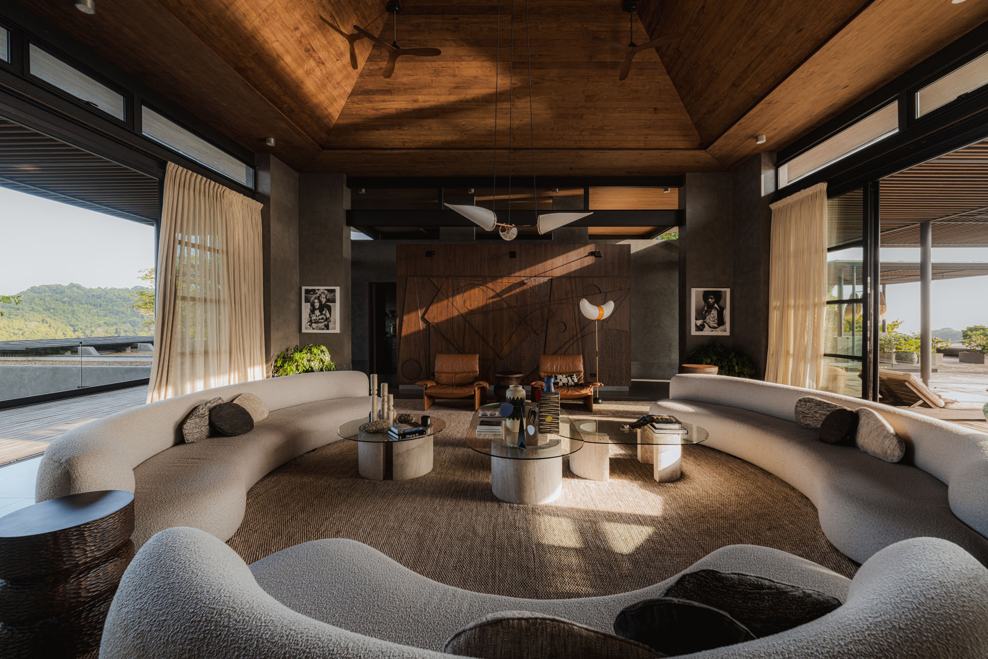 Expansive central living room with a high vaulted timber ceiling, symmetrical curved sofas, and large open glass doors at Dos Vistas in Cabuya, Costa Rica by Studio Saxe.